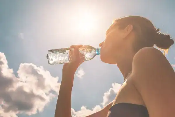 Hydration: The Secret Ingredient for a Toned Stomach and Enhanced Fitness 3 Image of woman drinking water to hydrate Sunbury-on-Thames after run.