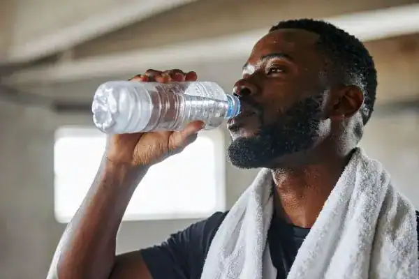Hydration: The Secret Ingredient for a Toned Stomach and Enhanced Fitness 1 Image of man drinking water to improve hydration Sunbury-on-Thames after work out.